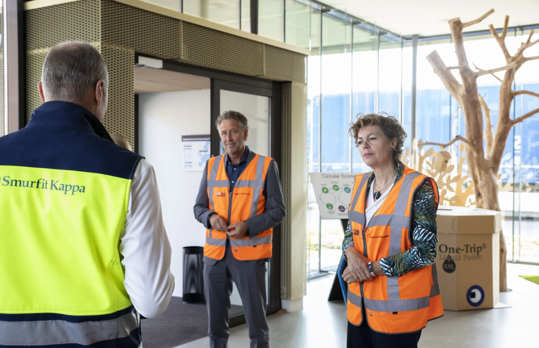 3 personen in een hesje in overleg